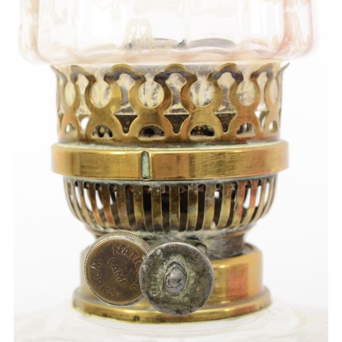 256 - A 19th/early 20th century brass and glass oil lamp, with clear and cranberry glass shade etched with... 