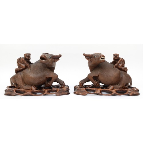 292 - A pair of 20th century Chinese carved hardwood water buffalo with boys riding their back, each with ... 