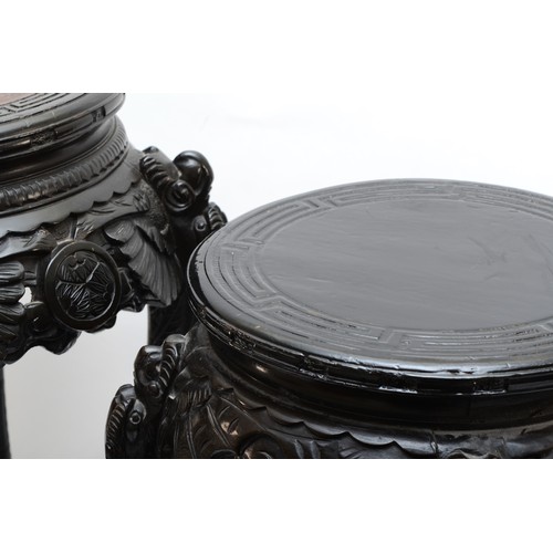 295 - Two 20th century carved Chinese hardwood stands, the tops each incised with Greek Key pattern, with ... 