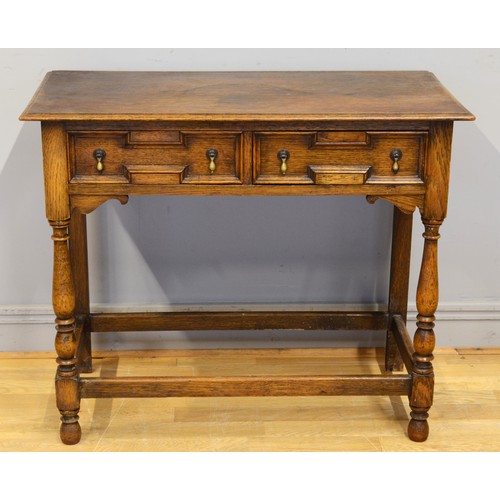 442 - An early 20th century oak Jacobean style twin panelled drawer low boy, each with brass drop handles ... 