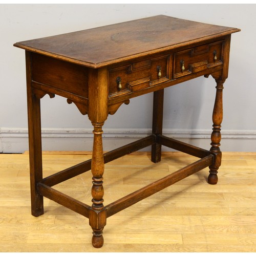 442 - An early 20th century oak Jacobean style twin panelled drawer low boy, each with brass drop handles ... 