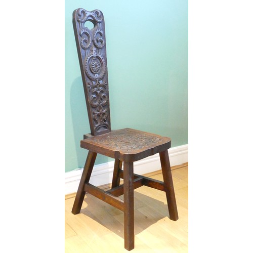 456 - A late 19th century Welsh carved oak spinning chair, having carved floral decoration, raised on outs... 