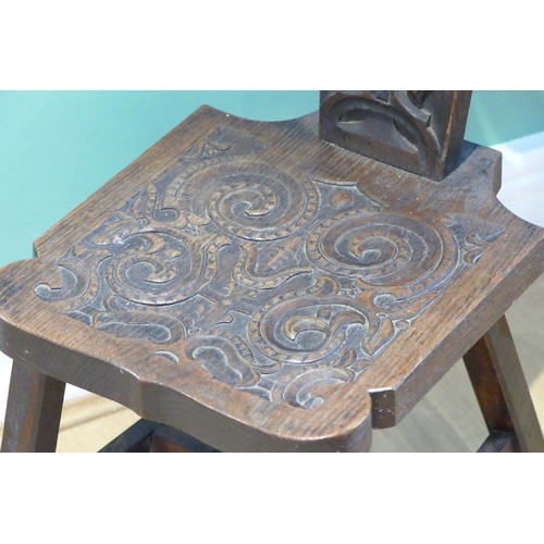 456 - A late 19th century Welsh carved oak spinning chair, having carved floral decoration, raised on outs... 