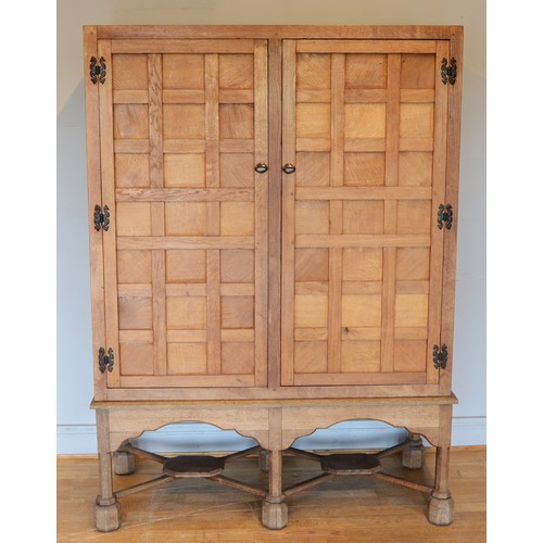 460 - A 20th century carved oak twin panelled door cupboard (converted from a tallboy) the doors with late... 