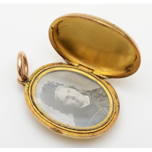 435 - A Victorian unmarked gold oval locket, tests as 15cts, with all over floral engraved decoration, 23 ... 