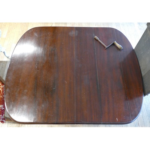 366 - An Edwardian mahogany wind out dining table, of oval form raised on claw and ball feet, with extra l... 