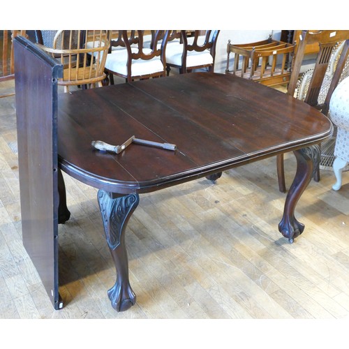 366 - An Edwardian mahogany wind out dining table, of oval form raised on claw and ball feet, with extra l... 