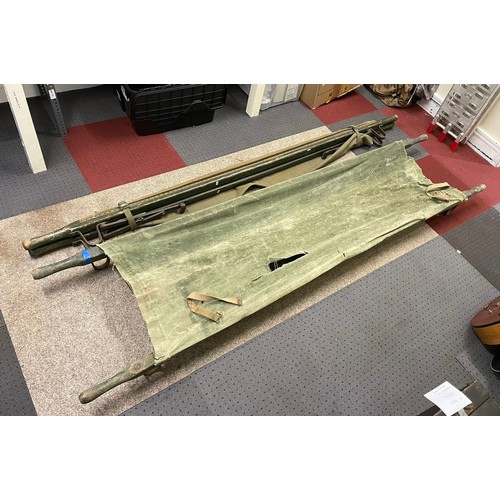 576 - A 1955 military wood and canvas field stretcher, with broad arrow stamp and date, 230cm, together wi... 