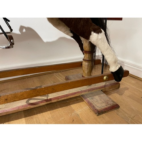 219 - A Pinto rocking horse, having red roan skin covering with horse hair mane and tail, glass eyes, leat... 