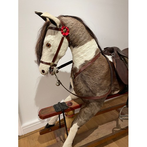 219 - A Pinto rocking horse, having red roan skin covering with horse hair mane and tail, glass eyes, leat... 