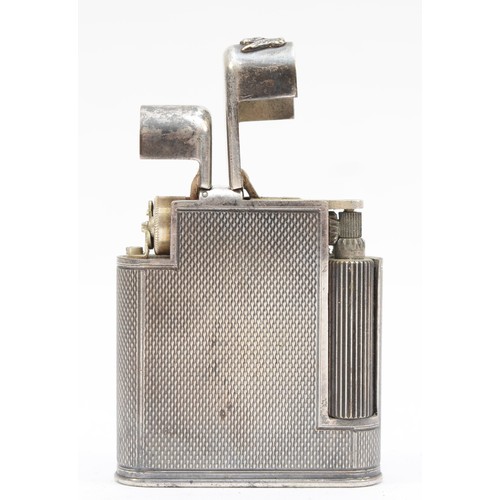 A silver-plated 'The Charles' petrol pocket lighter, c. 1950, stamped 'The Charles Lighter', MADE IN ENGLAND, patent number 626.585, DOMINION & FOREIGN PATENTS GRANTED, of slim rectangular form, engine-turned casing, double entry hinged lids with innovative internal mechanical features, including a revolving flint tube to provide even wear to the flint, and a rear barrel containing spare flint chambers so that semi-automatic loading of the spare flint can be undertaken, height 4.7cm.
