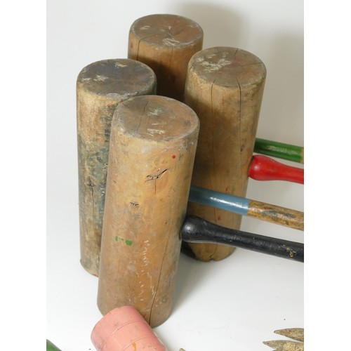 221 - An early 20th century cased croquet set, with hickory shaft mallets, turned painted wooden balls, an... 