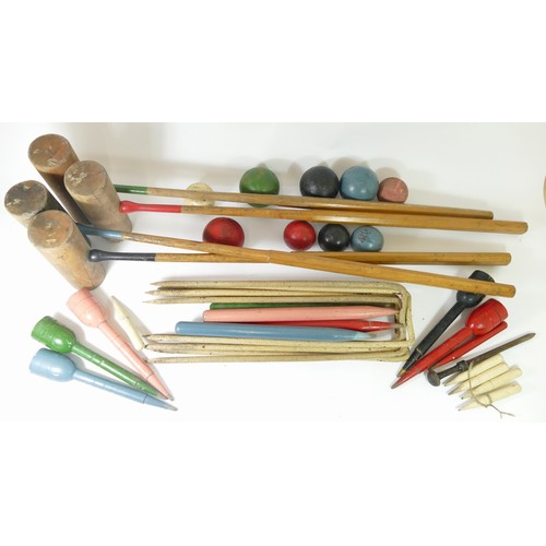 221 - An early 20th century cased croquet set, with hickory shaft mallets, turned painted wooden balls, an... 