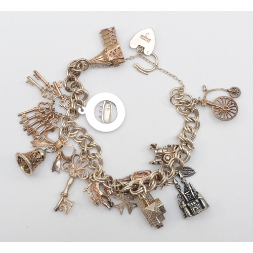 157 - A silver heart shaped clasped charm bracelet with charms, 47gm.