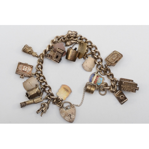 158 - A silver heart shaped clasped charm bracelet with souvenir charms, 67gm.