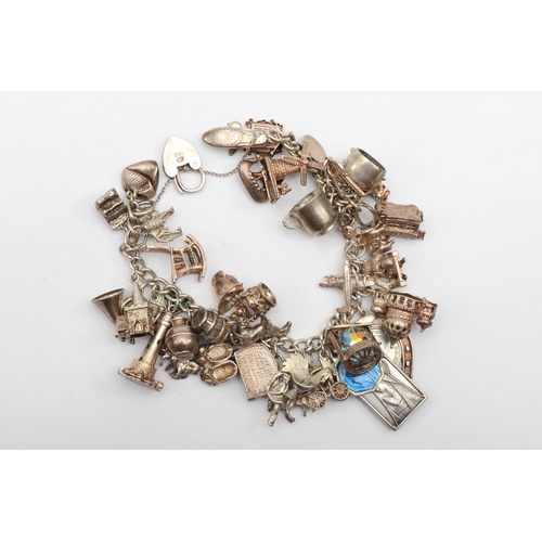 159 - A silver heart shaped clasped charm bracelet with religious charms, 107gm.