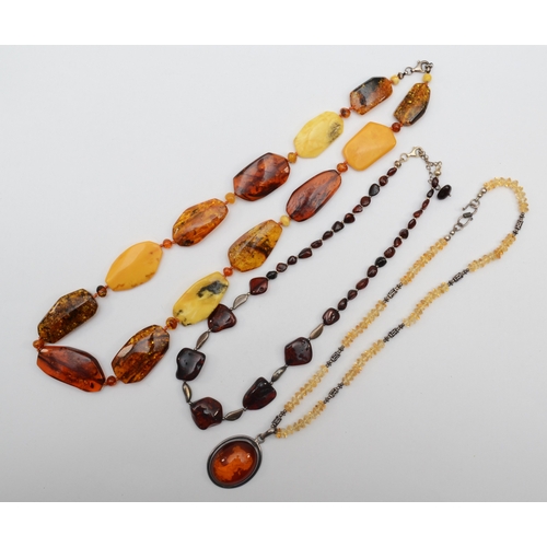 162 - An amber free form beaded necklace with silver clasp, 61cm, together with a silver relief carved ova... 