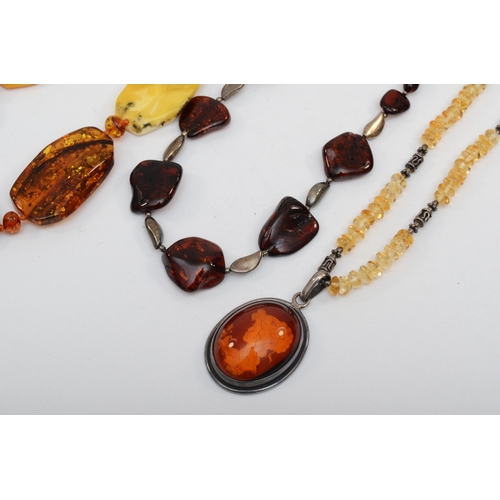 162 - An amber free form beaded necklace with silver clasp, 61cm, together with a silver relief carved ova... 