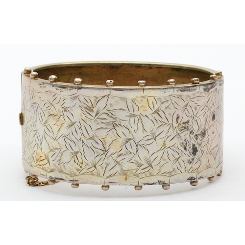 178 - An early 20th century silver cuff bangle with foliate chased decoration, 54mm, 23gm.