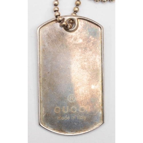 179 - Gucci, a silver dog tag pendant on a beaded chain 49 x 27mm, together with a t-bar bracelet, 45gm.