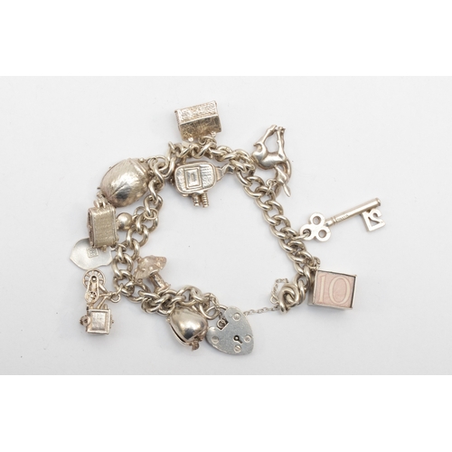 183 - A silver heart shaped clasped charm bracelet with charms, 65gm.