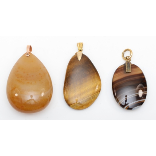 219 - A 9ct gold tiger's eye pendant, 48 x 26mm, together with two agate pendants.