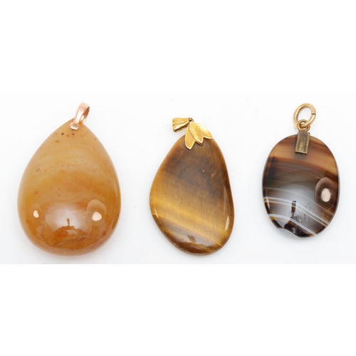 219 - A 9ct gold tiger's eye pendant, 48 x 26mm, together with two agate pendants.