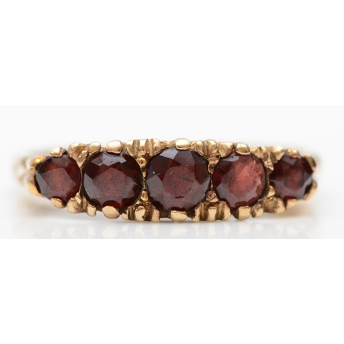 220 - A 9ct gold graduating five stone garnet dress ring, P, 2.8gm.