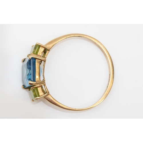 256 - A 9ct gold blue topaz and peridot dress ring, T-U, 2.7gm.