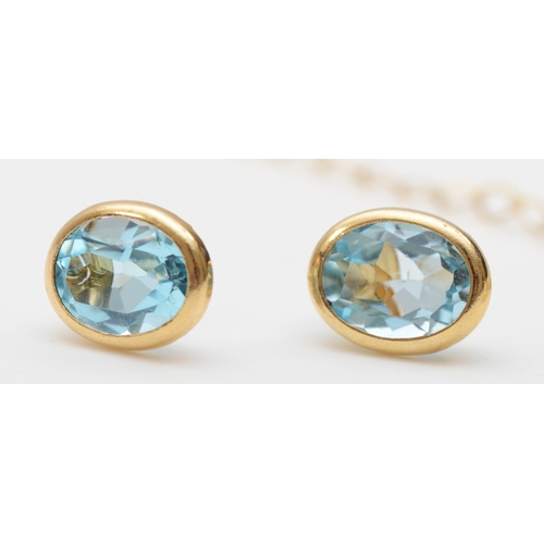 258 - An unmarked gold blue topaz pendant on 9k chain, with matching ear studs, 2.3gm.