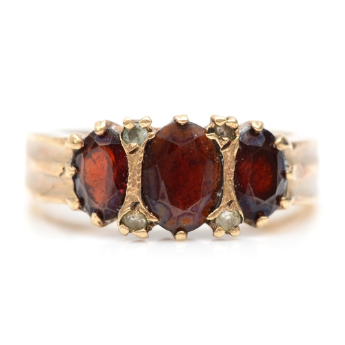 261 - A 9ct gold three stone garnet dress ring, M-N, 4gm.