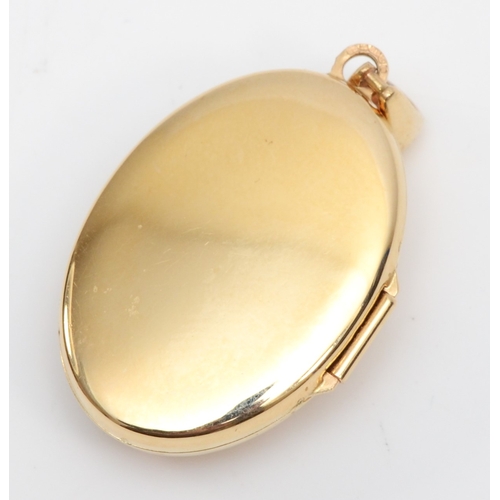 311 - A 14ct gold sapphire and enamel oval locket, 35 x 19mm, 4.4gm.