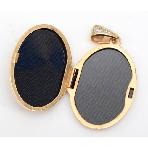 311 - A 14ct gold sapphire and enamel oval locket, 35 x 19mm, 4.4gm.