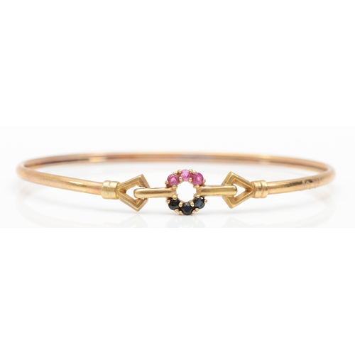 342 - A 9ct gold ruby and sapphire bangle, internal 59mm, 4.6gm.