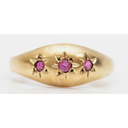 411 - A 9ct gold three stone ruby dress ring, N, 1.7gm.