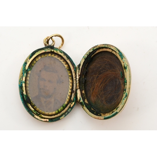 425 - An unmarked gold front and backed oval locket, with chased decoration, 26 x 18mm, 6.9gm.