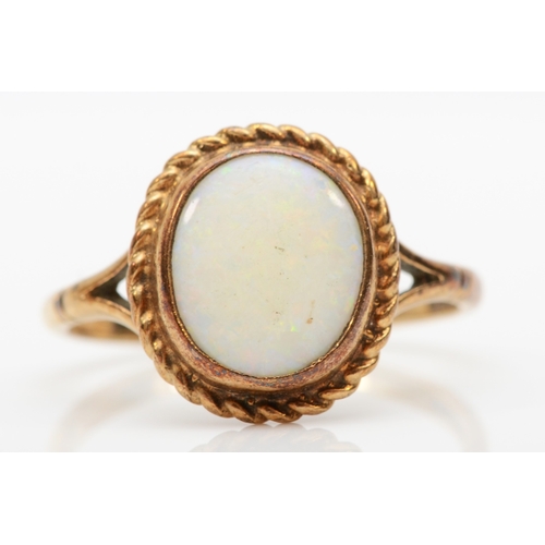 476 - A 9ct gold opal dress ring, with rope twist boarder, flashes of red, blue and green, U, 3.4gm.