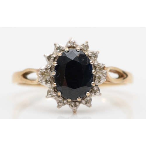 506 - A 9ct gold sapphire and diamond oval cluster ring, P, 2.1gm.