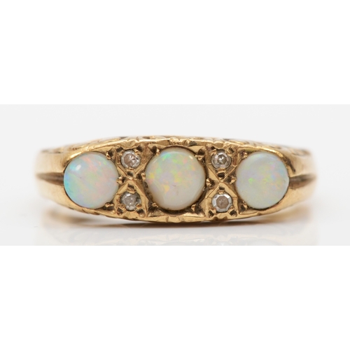 515 - A 9ct gold three stone opal dress ring, flashes of red, orange, green and blue, Q, 3.9gm.