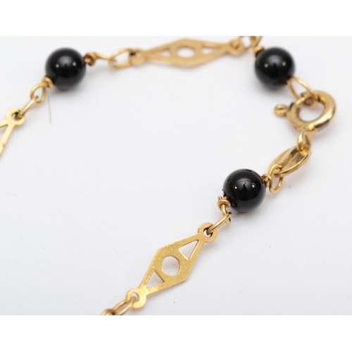 531 - A 9ct gold fancylink necklace with onyx beads and cross pendant, 18mm, 5.8gm.