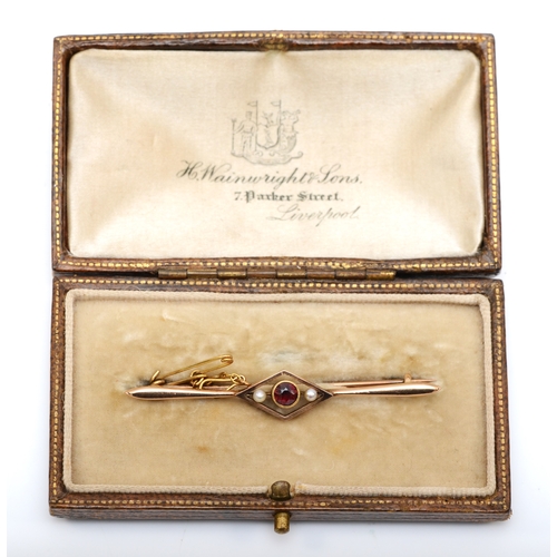 589 - An Edwardian 15ct rose gold garnet and seed pearl bar brooch, safety chain and original box, 55mm, 2... 