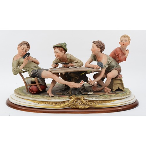 150 - A 20th century Capodimonte porcelain figure, The Cheats, modelled by B.Merli, raised on an oval wood... 