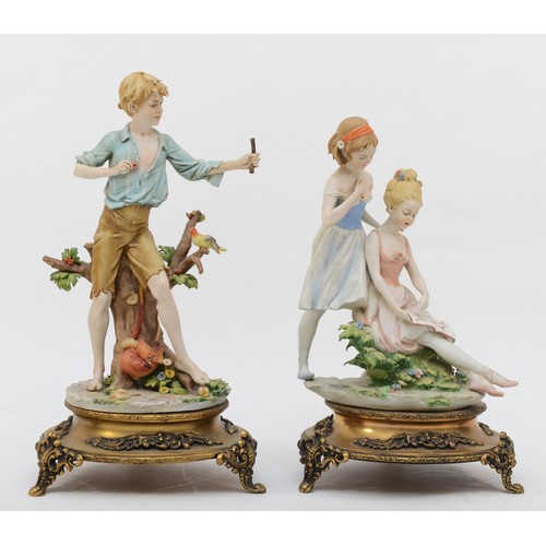 162 - Two 20th century Capodimonte painted porcelain figures, two females reading a book and a boy with a ... 