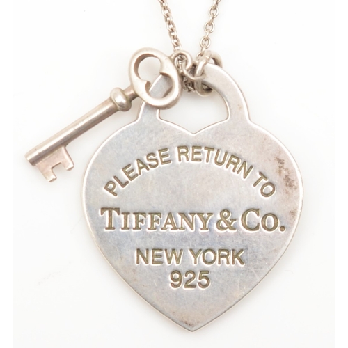 128 - A silver Tiffany & Co heart shaped tag and key pendant, on silver chain, 25 x 20mm, 8gm.