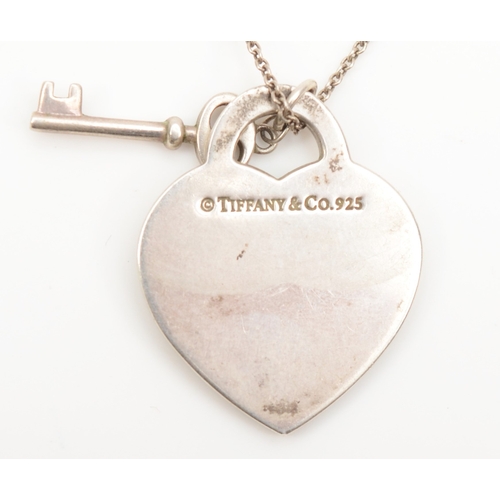 128 - A silver Tiffany & Co heart shaped tag and key pendant, on silver chain, 25 x 20mm, 8gm.