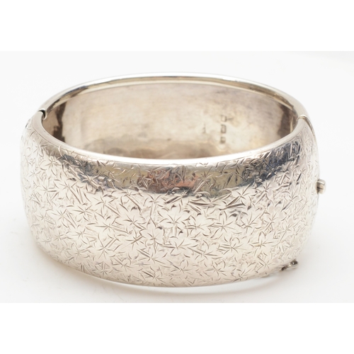 142 - A Victorian silver snap bangle with chased foliate decoration,  maker rubbed, Birmingham 1890, 58 x ... 