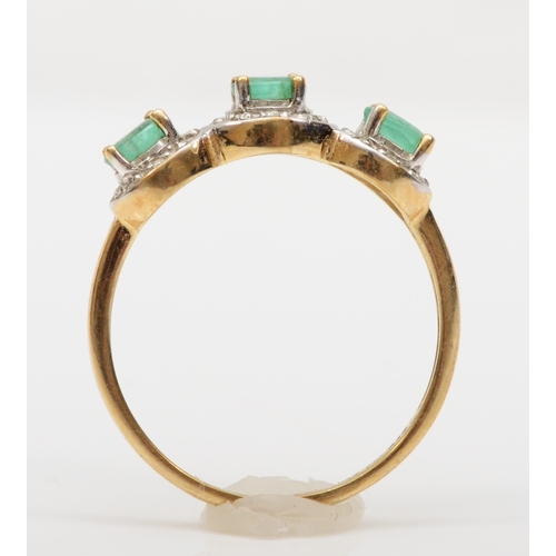 167 - A 9ct gold three stone emerald dress ring, with eight cut diamond surrounds, P, 2.1gm.