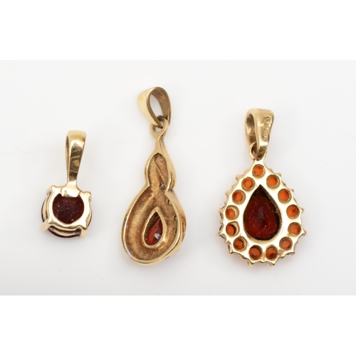 175 - A 9ct gold pear cut garnet cluster pendant, 20 x 10mm, together with two unmarked gold pendants, 3gm... 