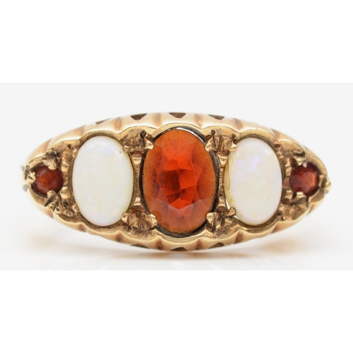 188 - A 9ct gold five stone opal and garnet dress ring, flashes of orange, blue and green, P-Q, 3.1gm.