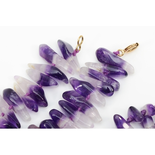 204 - A 9k gold clasped graduated tumbled amethyst necklace, 91cm, together with a similar necklace.